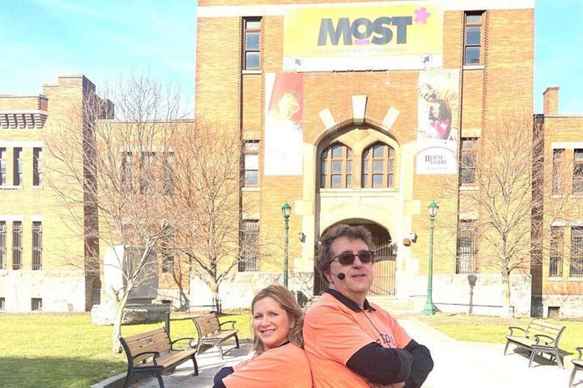 A building with a sign reading 'MOST' and a person in an orange shirt. 2