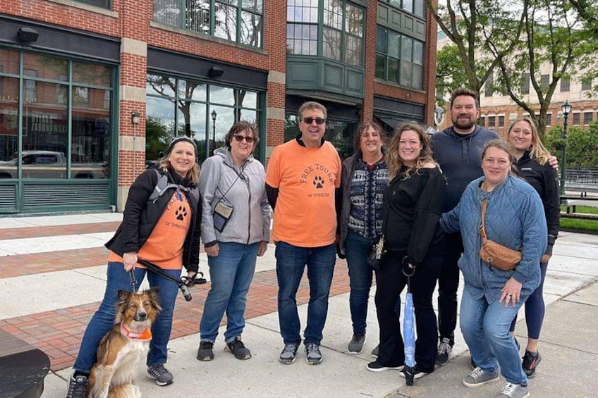 A group of people standing in front of a building with large windows and a brick facade. 3