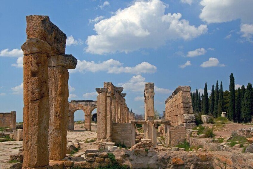 Ancient stone ruins with columns and an archway. 4