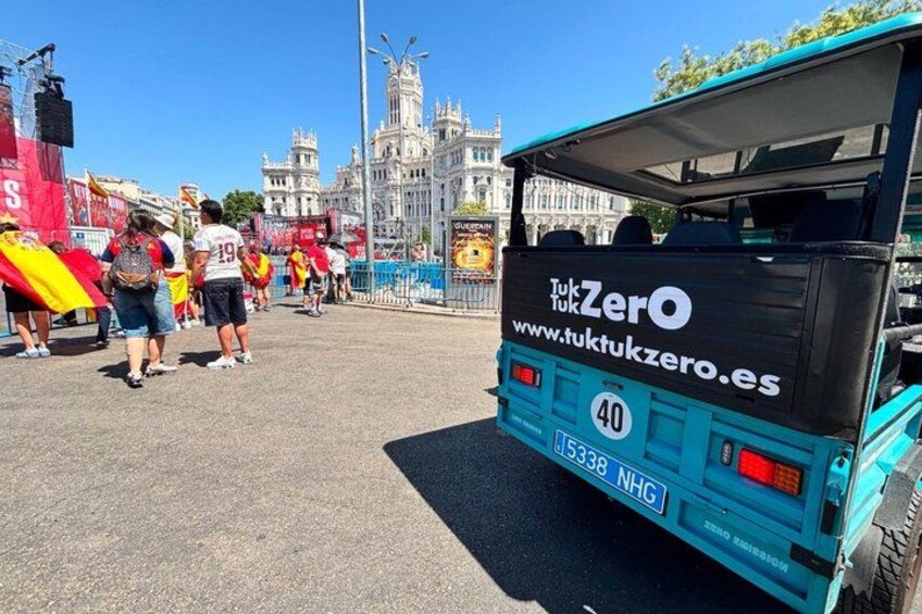 A blue tuk-tuk with 'TukkukZero' branding parked in front of a historic building. 4