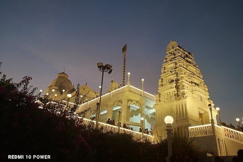 A temple with a large dome and a tall spire, illuminated by lights. 2