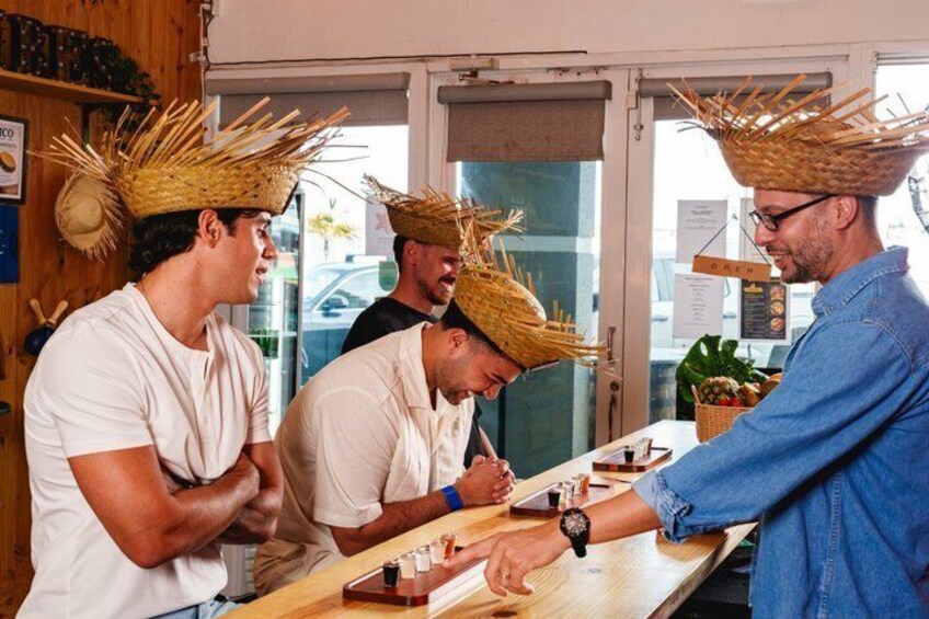 A group of people wearing straw hats, standing at a counter with a menu. 2