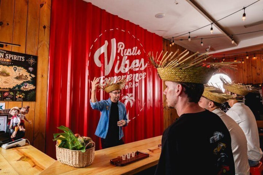 A person wearing a straw hat, a red curtain with text, and wooden walls. 4