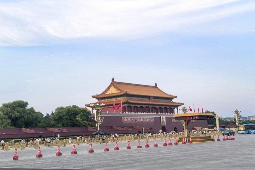 Een traditioneel Chinees gebouw met een rood dak en gouden versieringen, omgeven door rode en witte verkeerspalen. 2