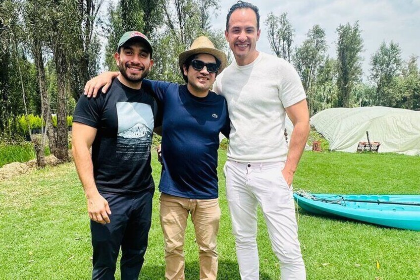 Tre persone in piedi all'aperto, con una tenda e un kayak sullo sfondo. 1