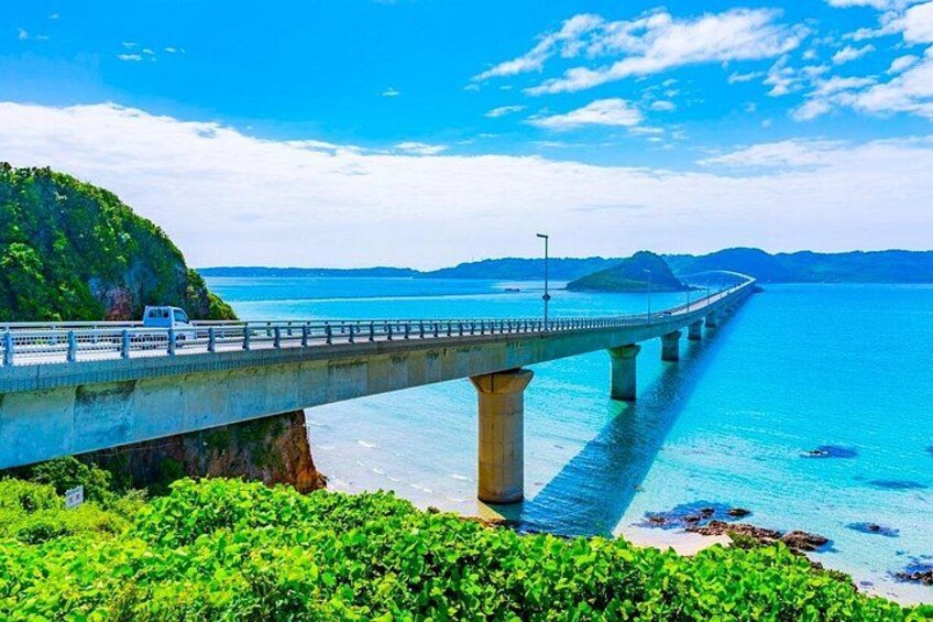 A bridge over a body of water with a mountainous landscape in the background. 3