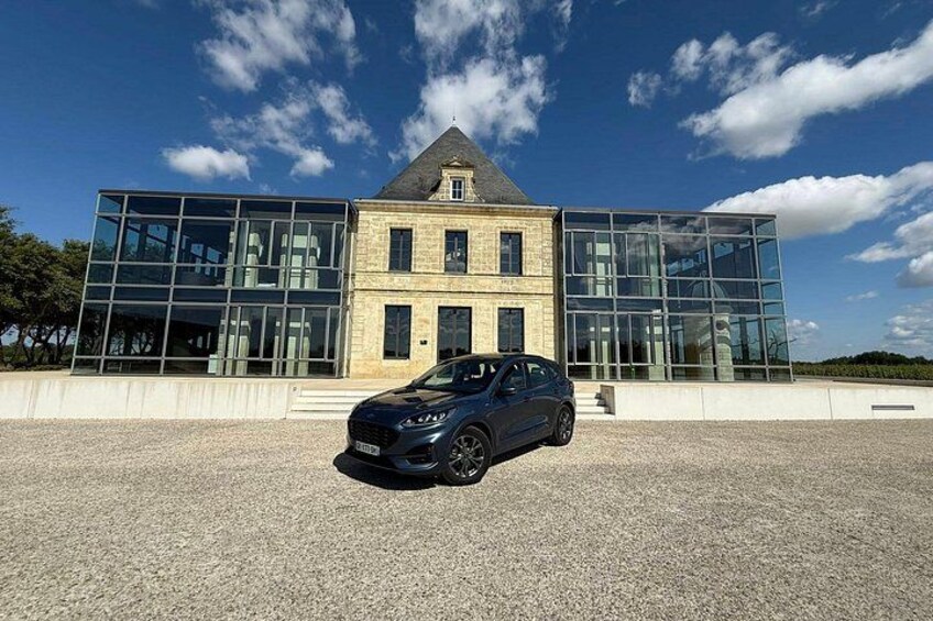 A modern building with large glass windows and a car parked in front. 5
