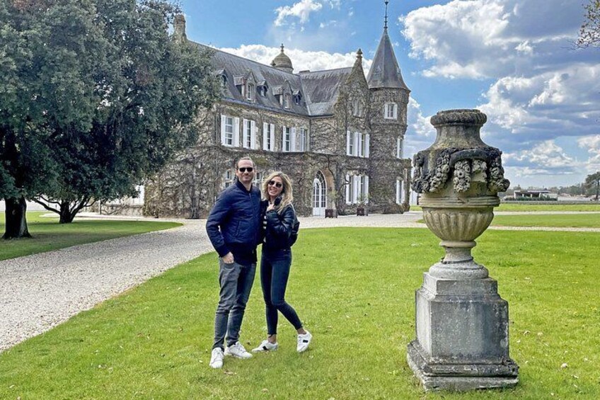 A historic building with a large lawn and a decorative urn. 1