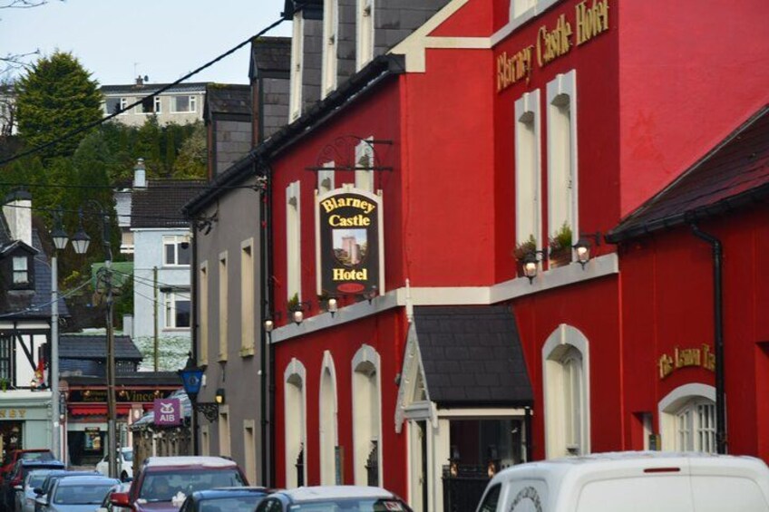 A red building with a sign that reads 'Blarney Castle Hotel.' 2