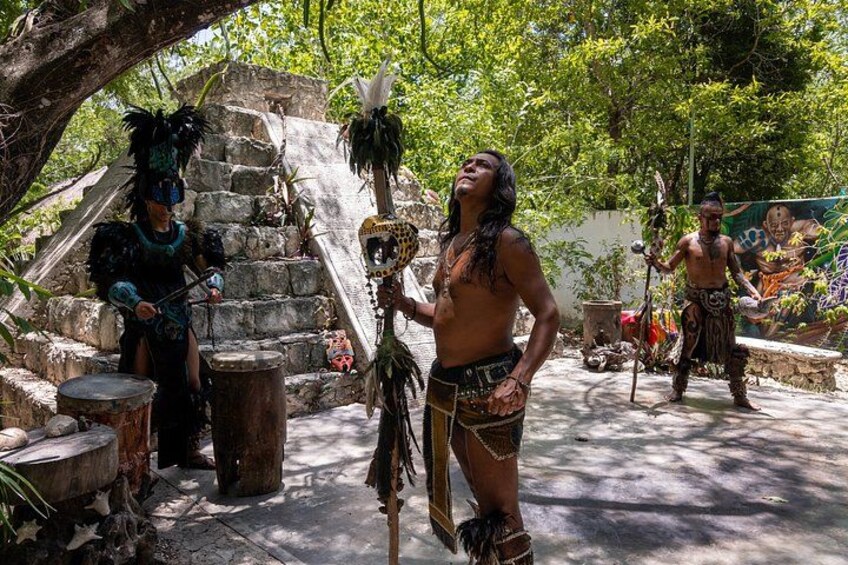 Una persona con vestimenta tradicional, una escalera de piedra y un entorno tropical. 5