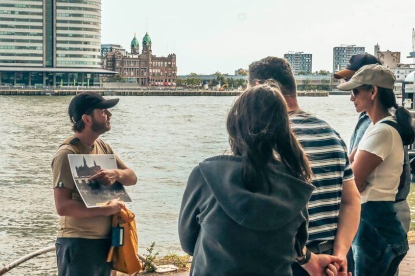 Un grupo de personas junto a la costa, con un paisaje urbano al fondo. 4