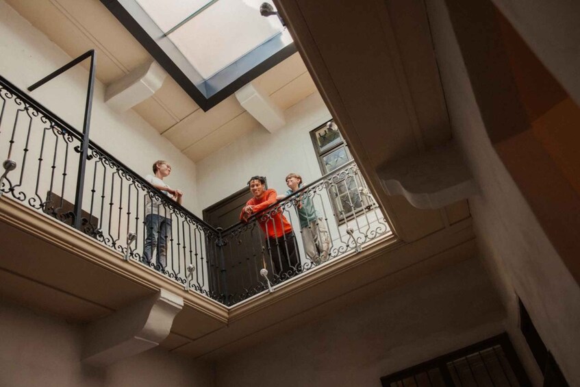 Un edificio de varios niveles con balcón, barandillas metálicas y un tragaluz. 5