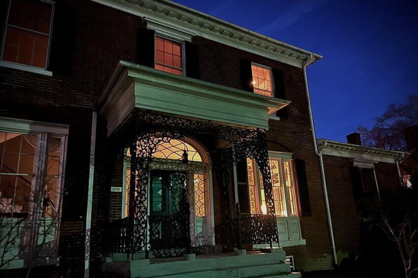 A brick house with a green porch and a decorative entrance. 2