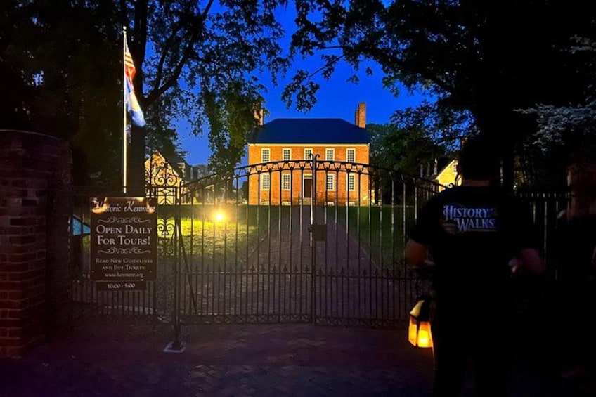 A historic building at dusk, a gated entrance, and a person with a 'History Walks' shirt. 5
