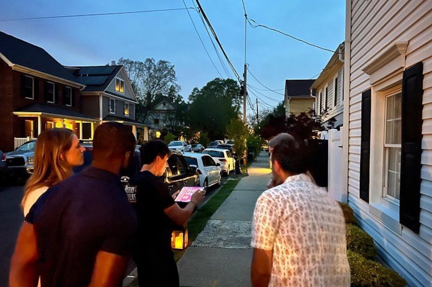 A group of people walking down a residential street at dusk. 4