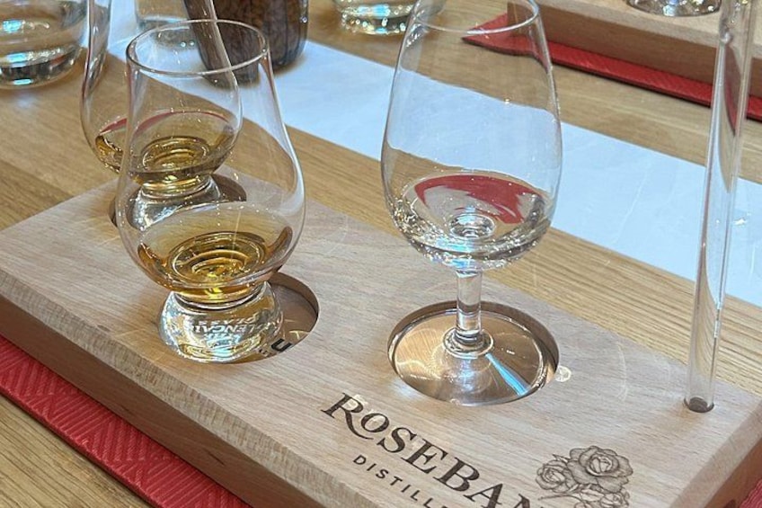 A wooden tray with two glasses of rosé wine and a bottle of Rosebank Distilled wine. 3