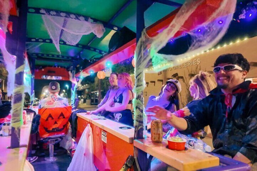 A Halloween-themed bar with festive decorations and a pumpkin costume. 1