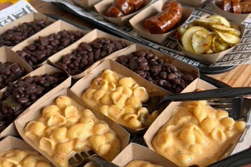 Macarrones con queso, frijoles negros y salchicha en recipientes de cartón. 3