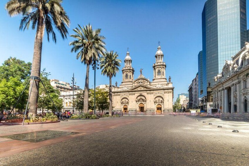 Une église historique dotée de deux tours, bordée de palmiers et entourée de bâtiments modernes. 4