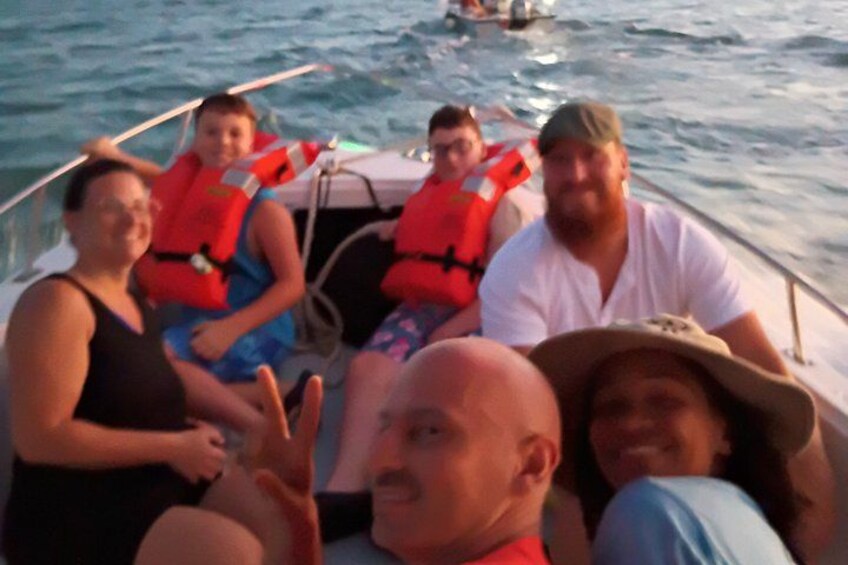 A group of people on a boat wearing life jackets. 2
