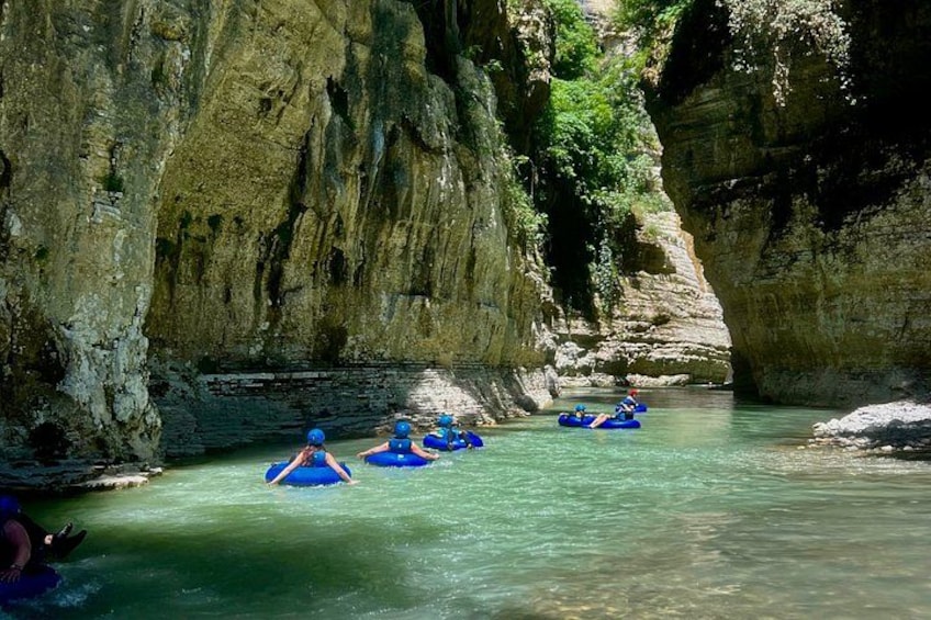 People rafting in a narrow canyon with steep rock walls. 3