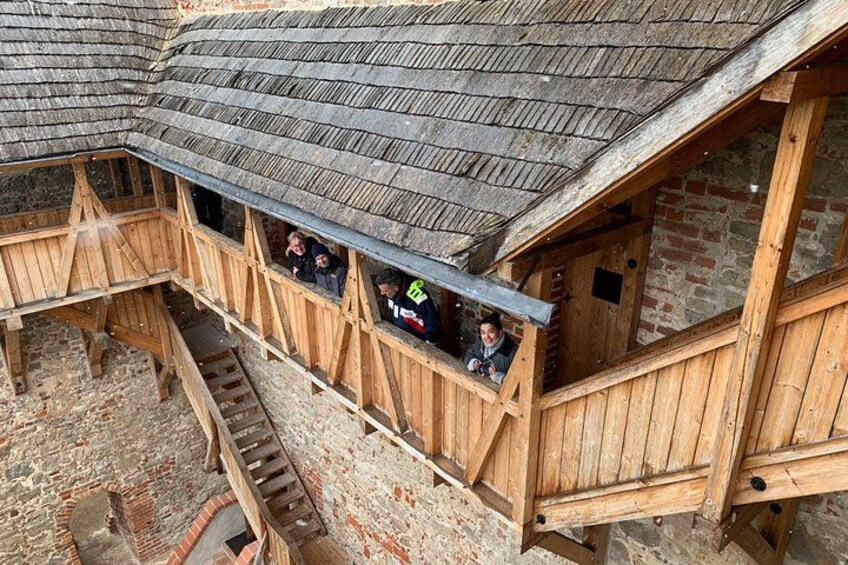 Ein hölzerner Balkon mit Personen darauf. 5
