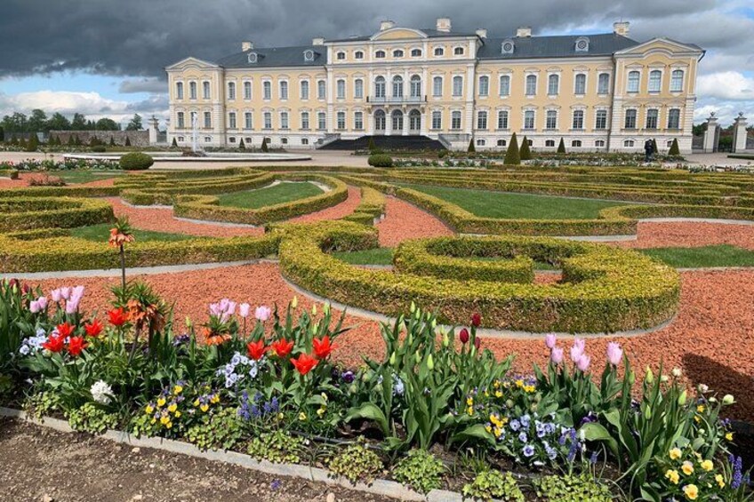 Ein prachtvolles Gebäude mit einem symmetrischen Garten davor. 2