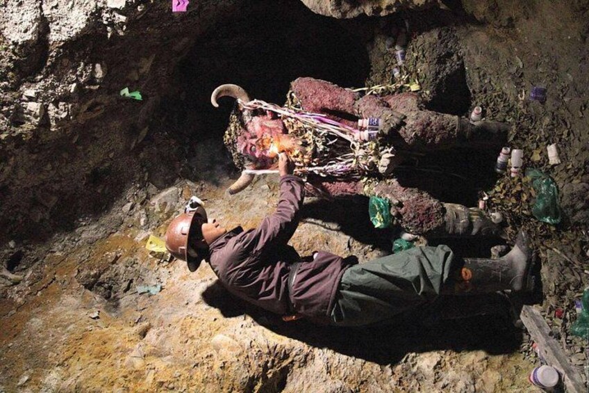 A person in a cave with a helmet, a backpack, and a rope. 2