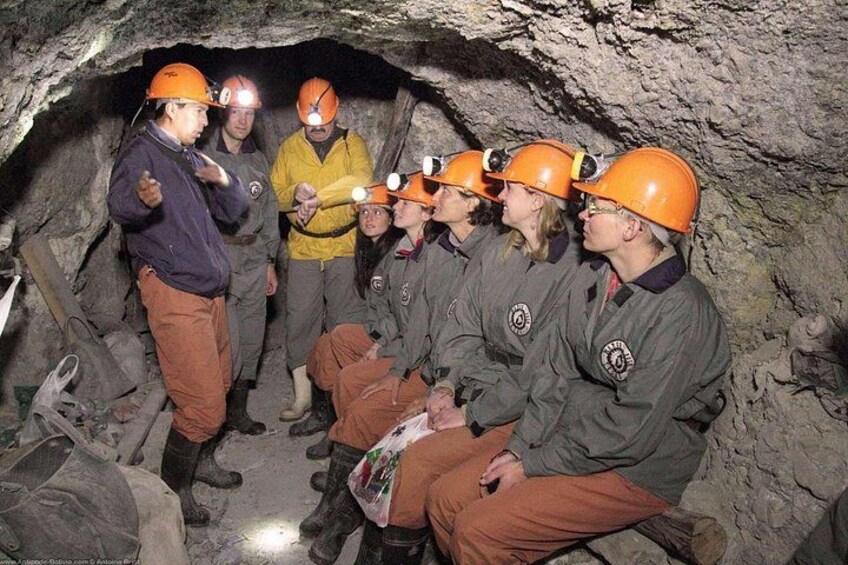A group of people in a cave wearing helmets and protective gear. 1