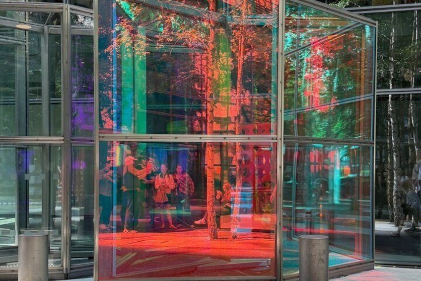 A glass structure with colorful reflections and a red carpet. 3