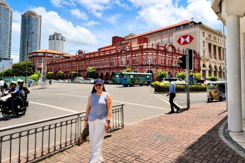 A woman standing on a sidewalk with a red building in the background. 5