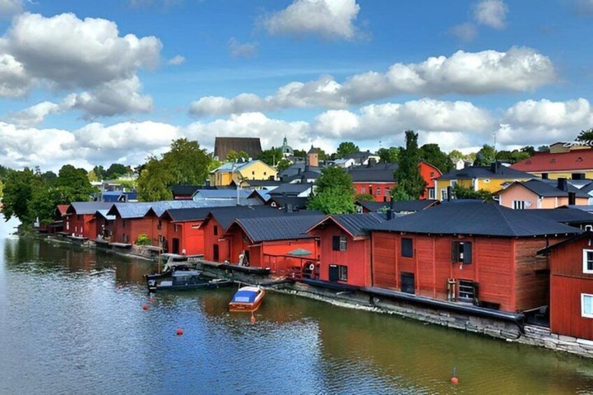 A waterfront with red buildings, a small boat, and a clear sky. 2