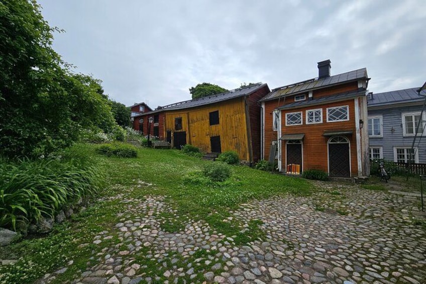 A cobblestone path, wooden houses, and lush greenery. 4