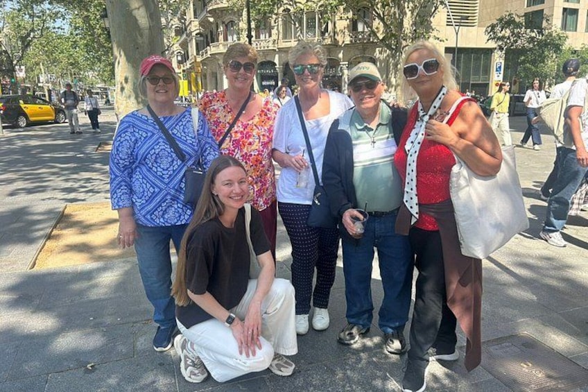 A group of people posing on a city street with trees and buildings in the background. 2