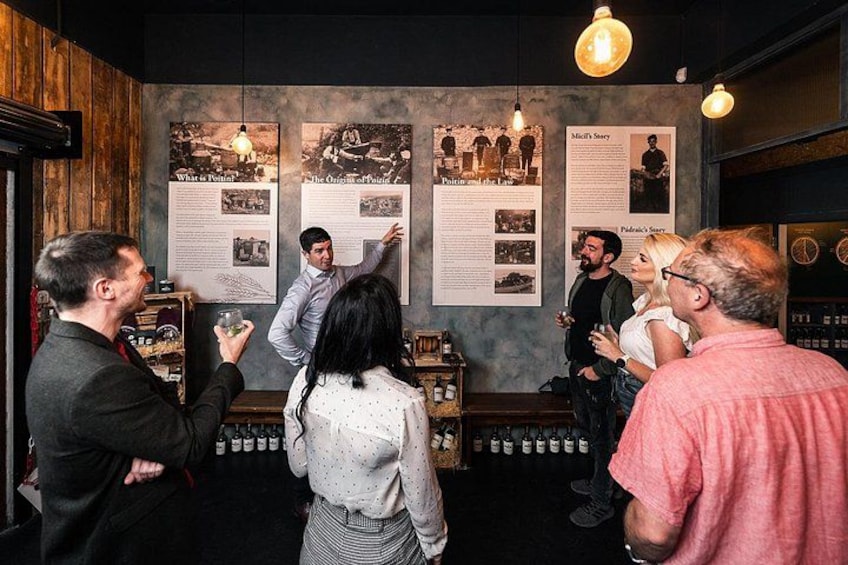 A group of people in a bar with wooden walls and hanging lights. There are posters on the wall and bottles on shelves. 1