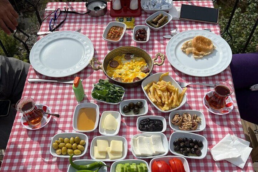 A picnic table with various food items including olives, cheese, olives, and a plate with bread. 1