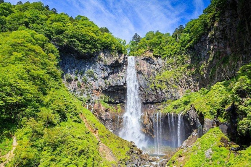 A waterfall cascading down a rocky cliff surrounded by lush green vegetation. 3