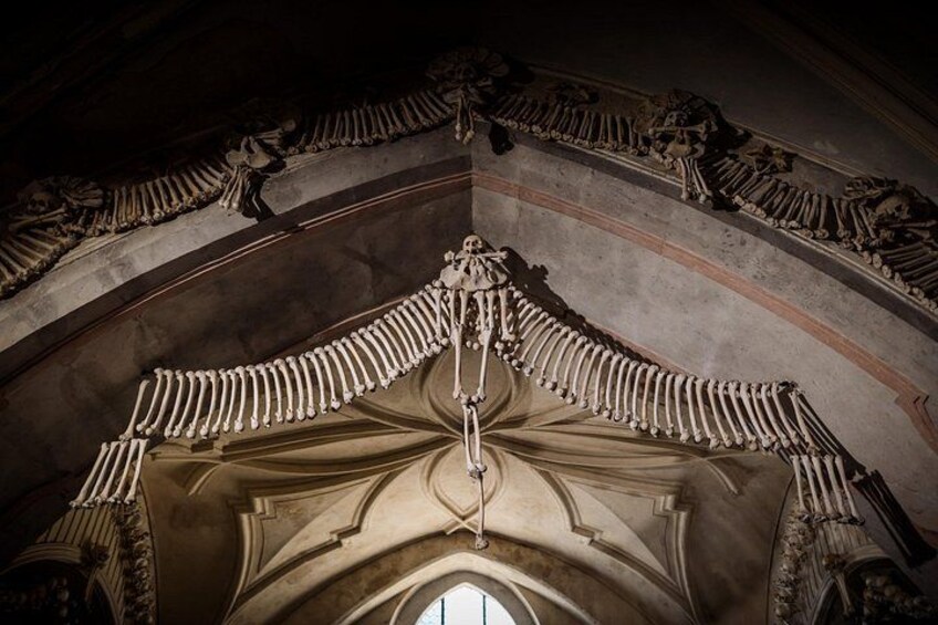 An interior of a cathedral with ribbed vaults and a large, ornate chandelier. 2