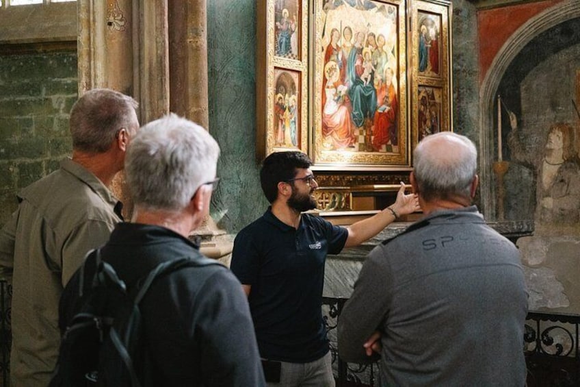 A group of people in a church, observing a religious painting. 5