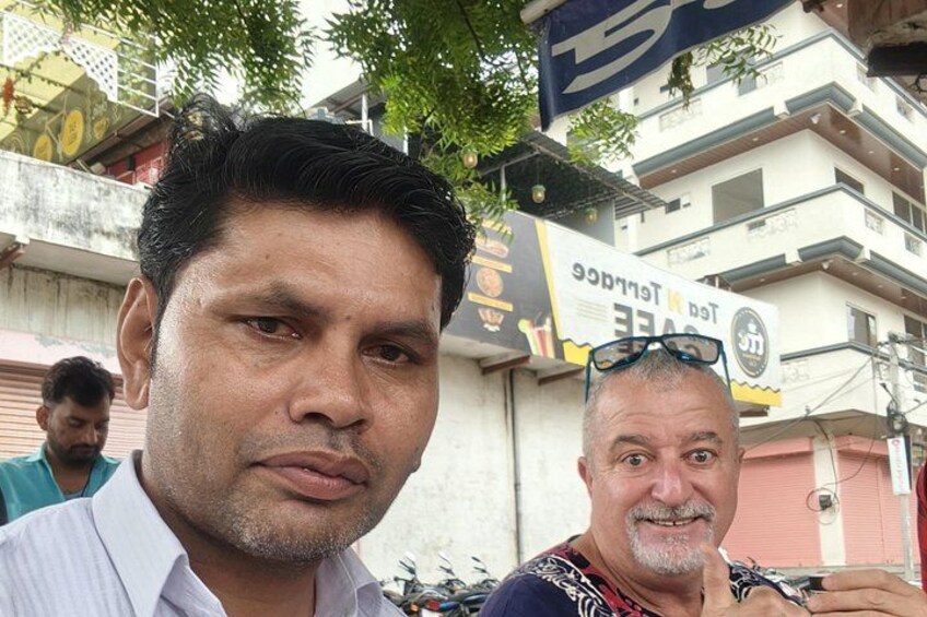 Two men in front of a building with a sign that reads 'Taj Hotel'. 4