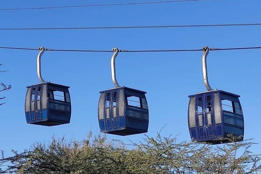 Drie kabelbanen hangen aan kabels voor een helderblauwe lucht. 5