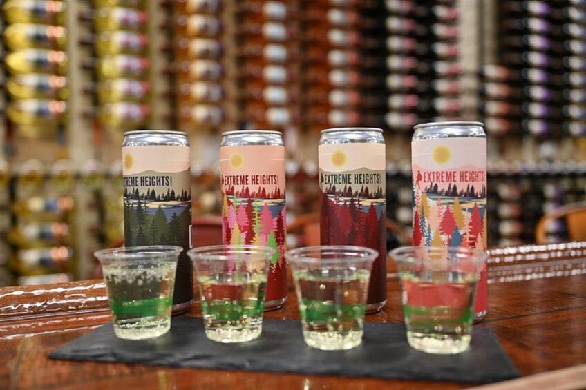 Latas de cerveza Extreme Heights y vasos para chupitos con cerveza sobre una barra. 3