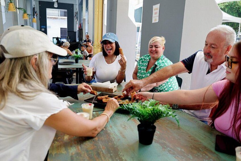 A group of people sharing food at a table outdoors. 3