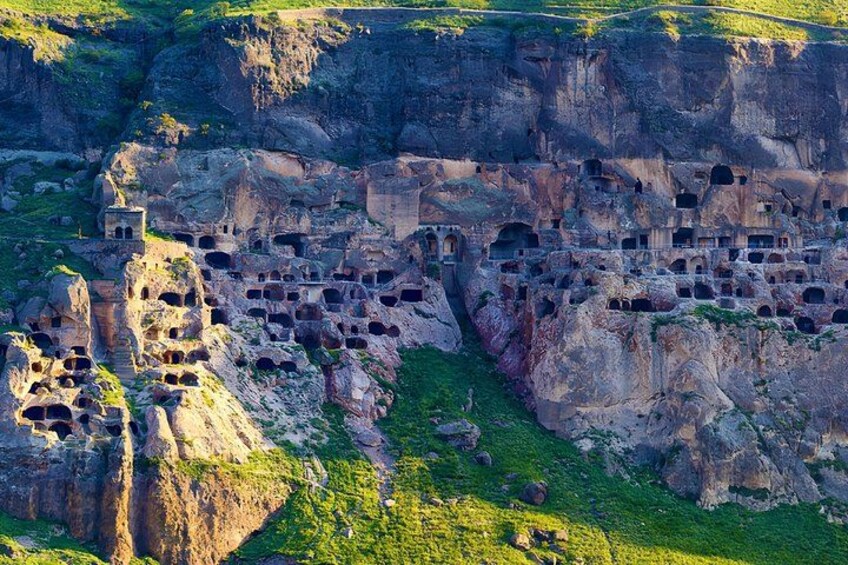 A rock formation with numerous caves and a tower. 4