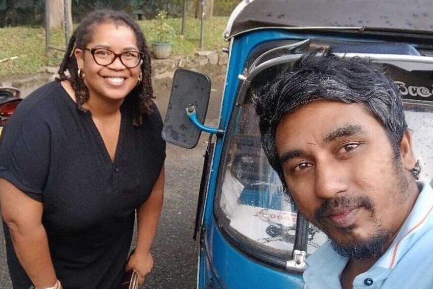 A person standing next to a blue auto-rickshaw. 4