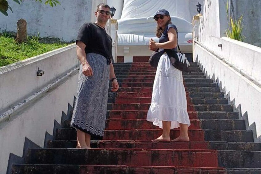 Two people standing on a staircase with a white building in the background. 3