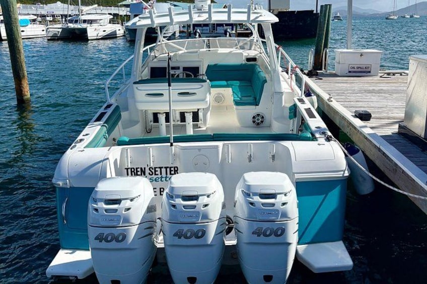 A boat docked at a marina with three 400 horsepower outboard motors. 5