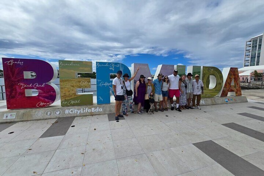 Eine Gruppe von Menschen steht vor einem großen Schild mit dem Wort 'BERBIDA' und verschiedenen Formulierungen wie 'Guadalupe', 'Dona Ana' und 'City LifeBda'. 1