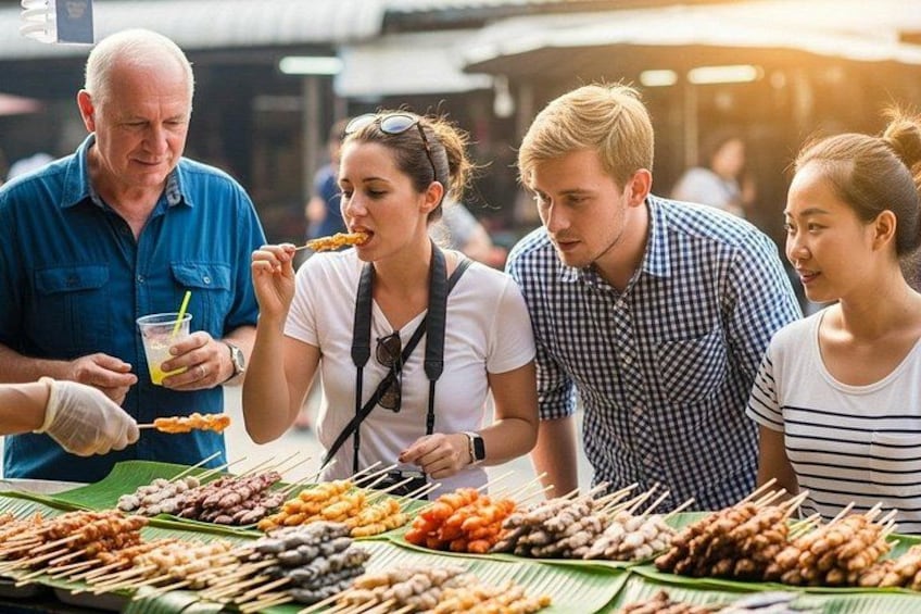 A group of people at a food stall with various skewers of food. 1