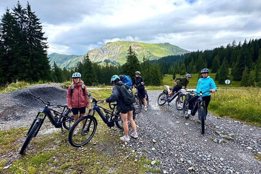 Un gruppo di ciclisti su un sentiero sterrato con montagne sullo sfondo. 4